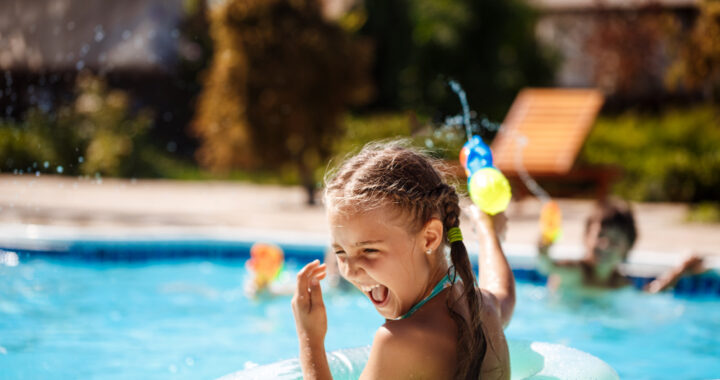 cheerful-children-playing-waterguns-rejoicing-jumping-swimming-in-pool