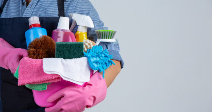 woman-is-holding-cleaning-product-gloves-rags-basin-white-wall